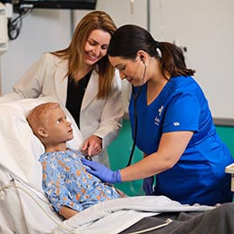 Nursing instructor teaching Joyce University nursing student on pediatric high fidelity mannequin