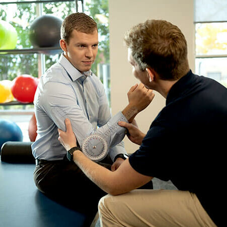 Joyce University OTA student practicing therapy techniques on instructor in skills lab