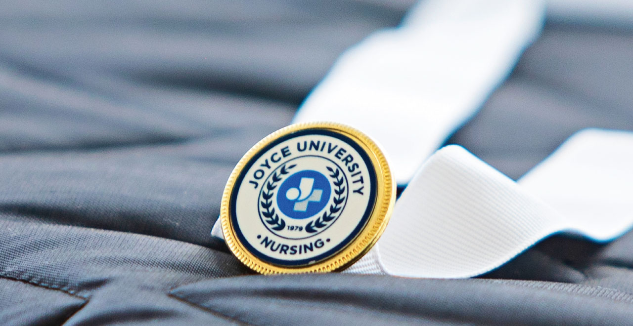 close up of a nursing pin attached to a ribbon sitting on a tablecloth